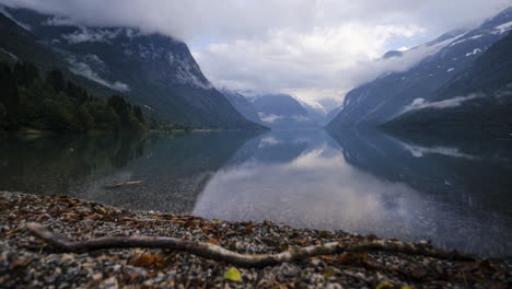 slider time lapse of beautiful norwegian lake with moving clouds reflecting in the still water