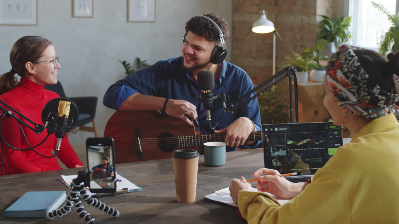 Due conduttrici che intervistano un cantante in uno studio podcast