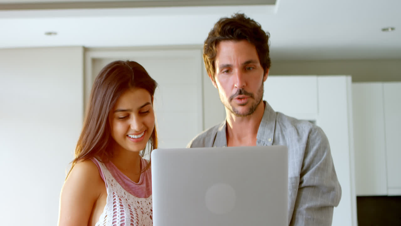 pareja usando una computadora portátil en casa 4k