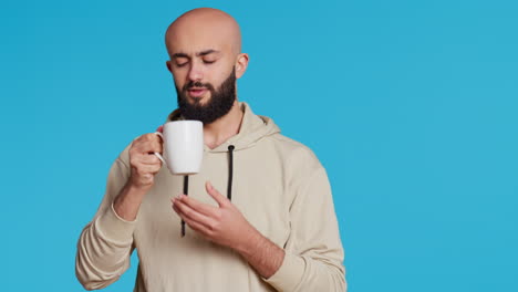 persona musulmana disfrutando del aroma fresco de la cafeína en el estudio