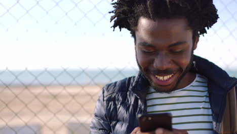 a black man texting on social media using a phone