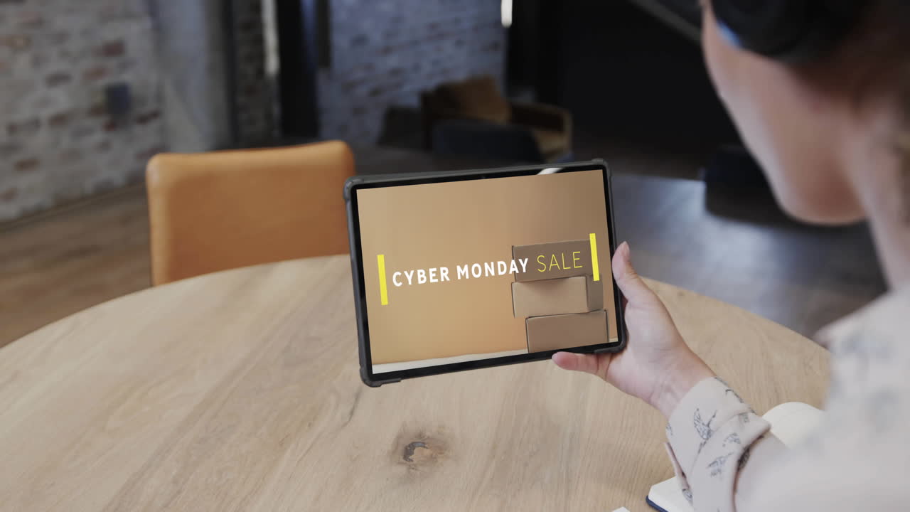 Biracial woman using tablet at cafe online shopping on cyber monday sale day, slow motion