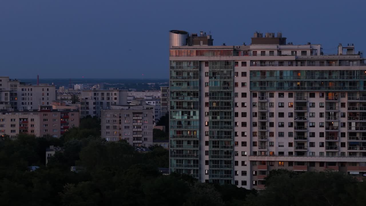 Moderna torre de apartamentos em Varsóvia na hora azul, distrito de Wola, Usina de Siekierki ao longe.