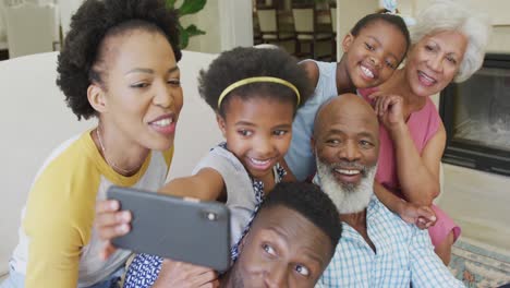 Glückliche-Afroamerikanische-Familie,-Die-Im-Wohnzimmer-Sitzt-Und-Ihr-Smartphone-Benutzt
