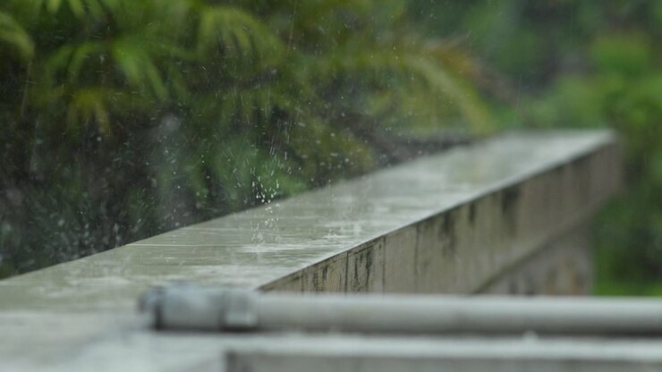 Slow motion rain falls on concrete during March storm, serene and moody