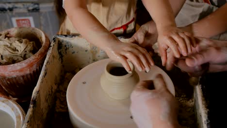 potter showing how to work with ceramic in pottery studio