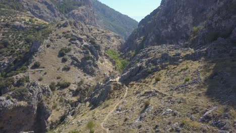 Toma-Aérea-Ascendente-De-Una-Pareja-En-Un-Mirador-De-Una-Ruta-De-Trekking-En-Un-Valle