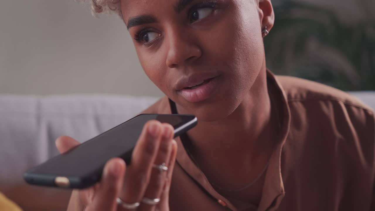 Close up african american woman holding mobile phone using loudspeaker
