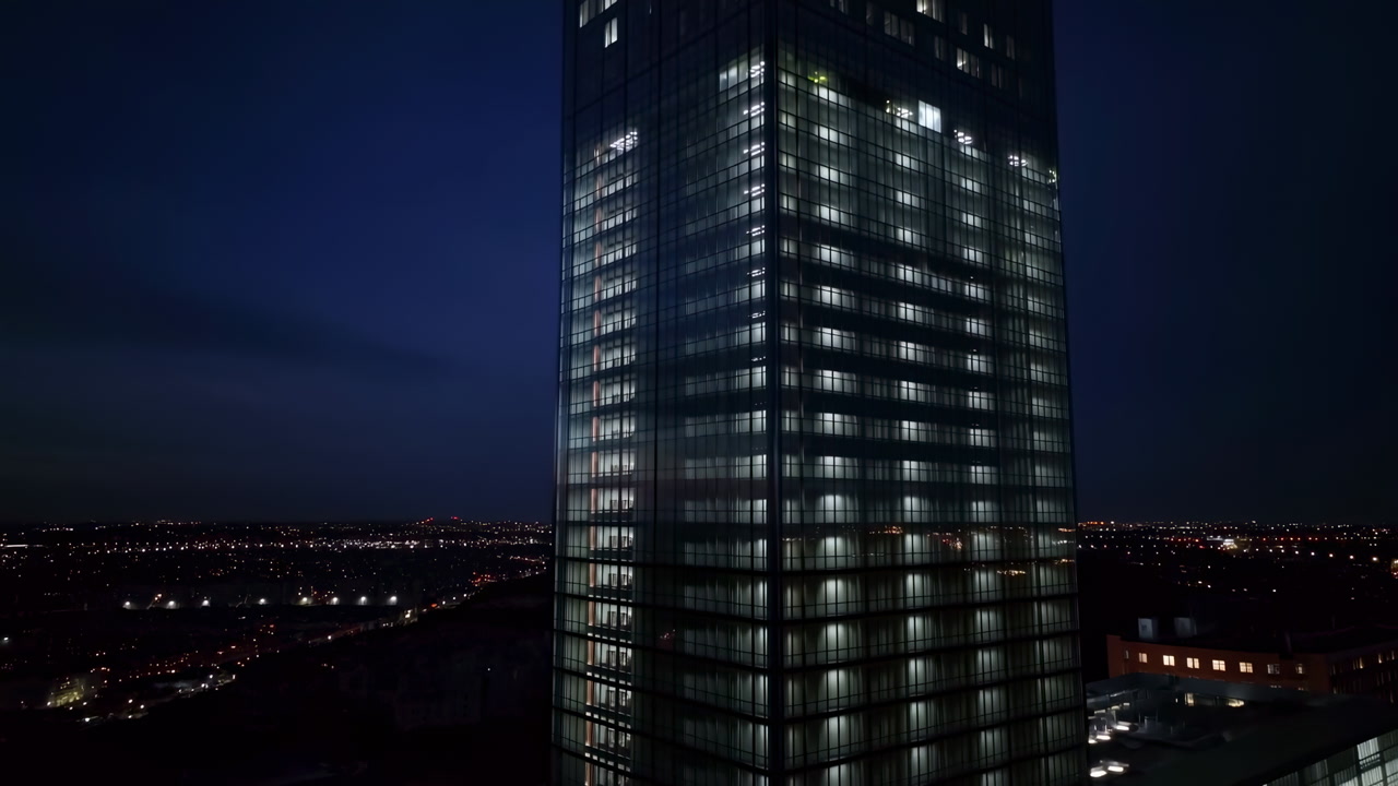 Nighttime Glass Office Tower Lit Windows, Aerial Drone Shot Of Modern Corporate Headquarters With Grid