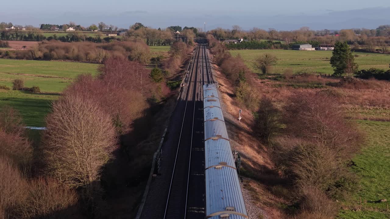Irish Rail Train Service Running along The Rural Fields In County Kildare, Ireland. - wide shot