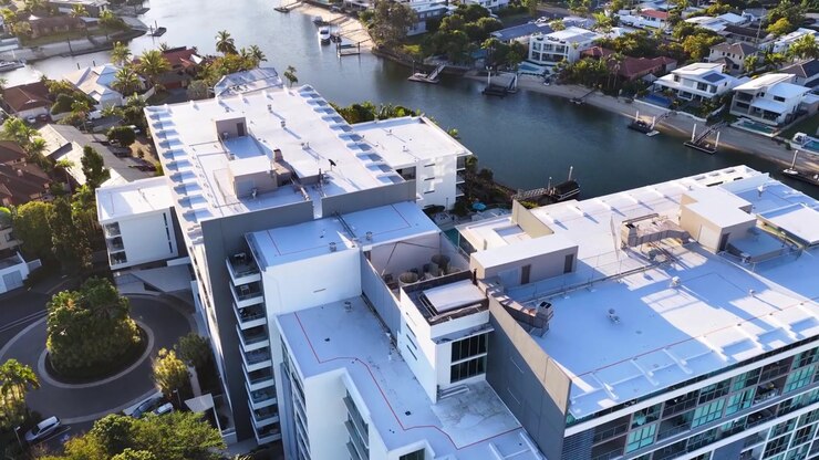 Droneoptagelse kredser om et moderne boligkompleks med udsigt over kanaler i Broadbeach, Gold Coast, Australien