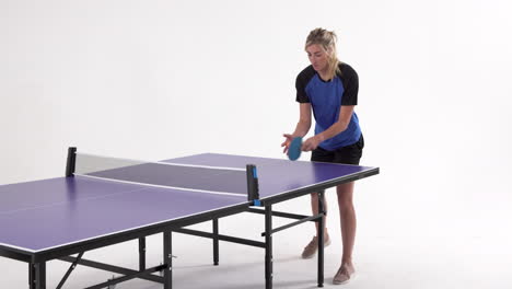 female table tennis player serving and passing the ball on white background, copy space