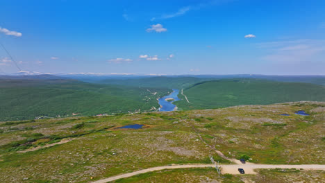 aerial view over a fell, revealing the sami bridge and teno river, in utsjoki, finland