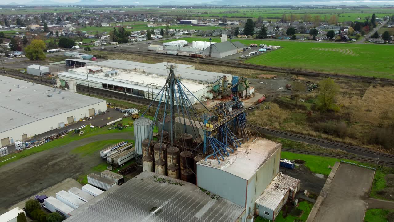 USA, OR, Harrisburg, 2025-11-23 - Vista con drone di un impianto di lavorazione chimica con vecchie tubature sporche che conducono a una torre presso CHS Nutrition, in autunno