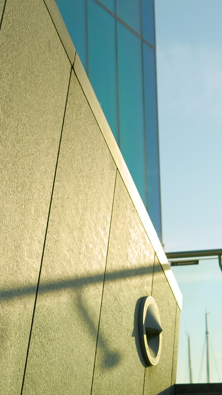 Uma tomada com inclinação vertical revelando arquitetura corporativa moderna com janelas de vidro azul e escadas de granito. Perfeito para conteúdo de imóveis e design urbano