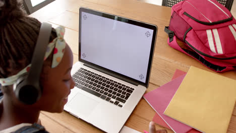 Feliz-Chica-Afroamericana-En-Clase-En-Línea-Usando-Auriculares-Y-Computadora-Portátil-Con-Espacio-Para-Copiar,-Cámara-Lenta