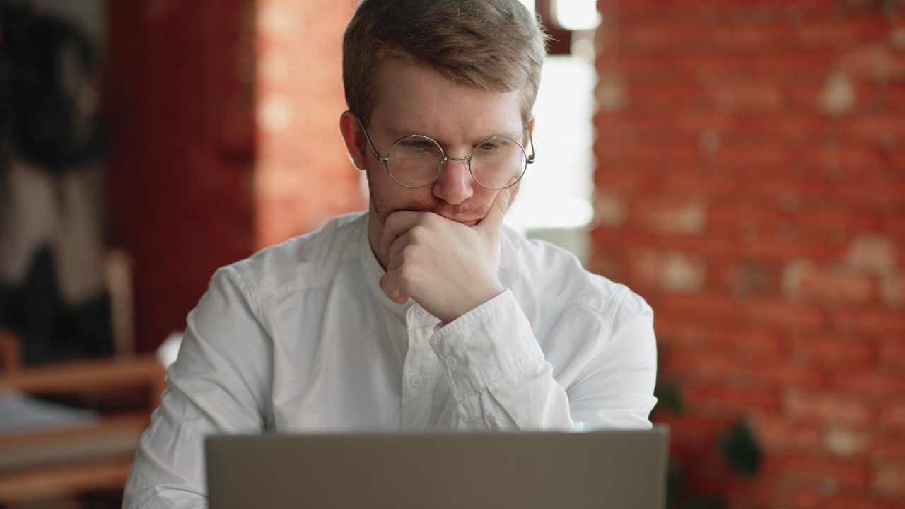 arquitecto o programador está trabajando remotamente sentado en un café con una computadora portátil comprobando la información mirando la pantalla