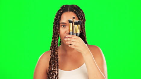 woman cover face with makeup brushes on green