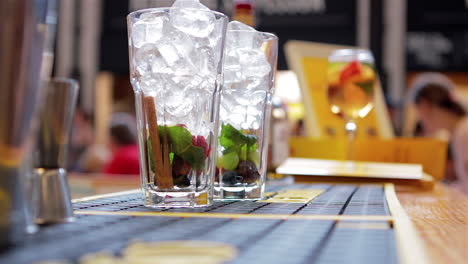 El-Barman-Vierte-Cubitos-De-Hielo-En-Un-Vaso-Para-Preparar-Cócteles,-Cámara-Lenta