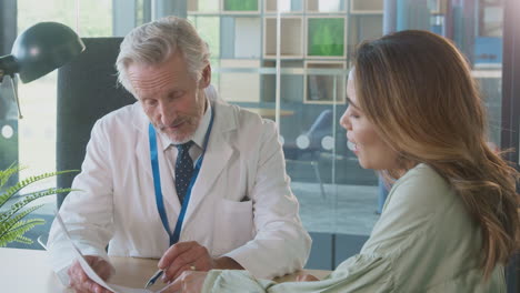 médico en el escritorio en la reunión de la oficina para discutir los resultados de las pruebas con la paciente femenina en el hospital