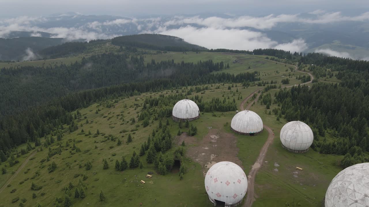 Aerial View of Mountaintop Radars in a Foggy Forest