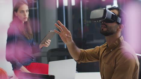 Mixed-race-businessman-using-vr-headset-during-meeting