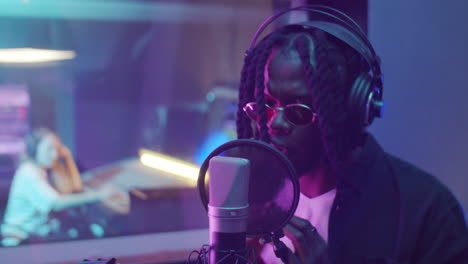 african american rapper recording music in studio