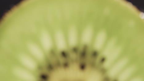 micro video de primer plano de una rebanada de fruta de kiwi con espacio de copia en fondo negro