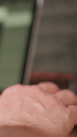 una toma de primer plano de una mano con un fondo muy borroso, que parece incluir equipos profesionales de producción de audio. el enfoque está en la mano, mientras que el fondo sugiere un espacio de trabajo creativo