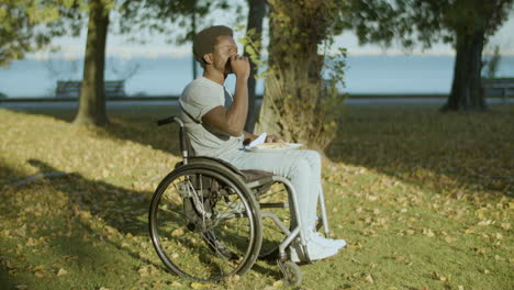 joven en silla de ruedas disfrutando de su almuerzo tardío en el parque de la ciudad