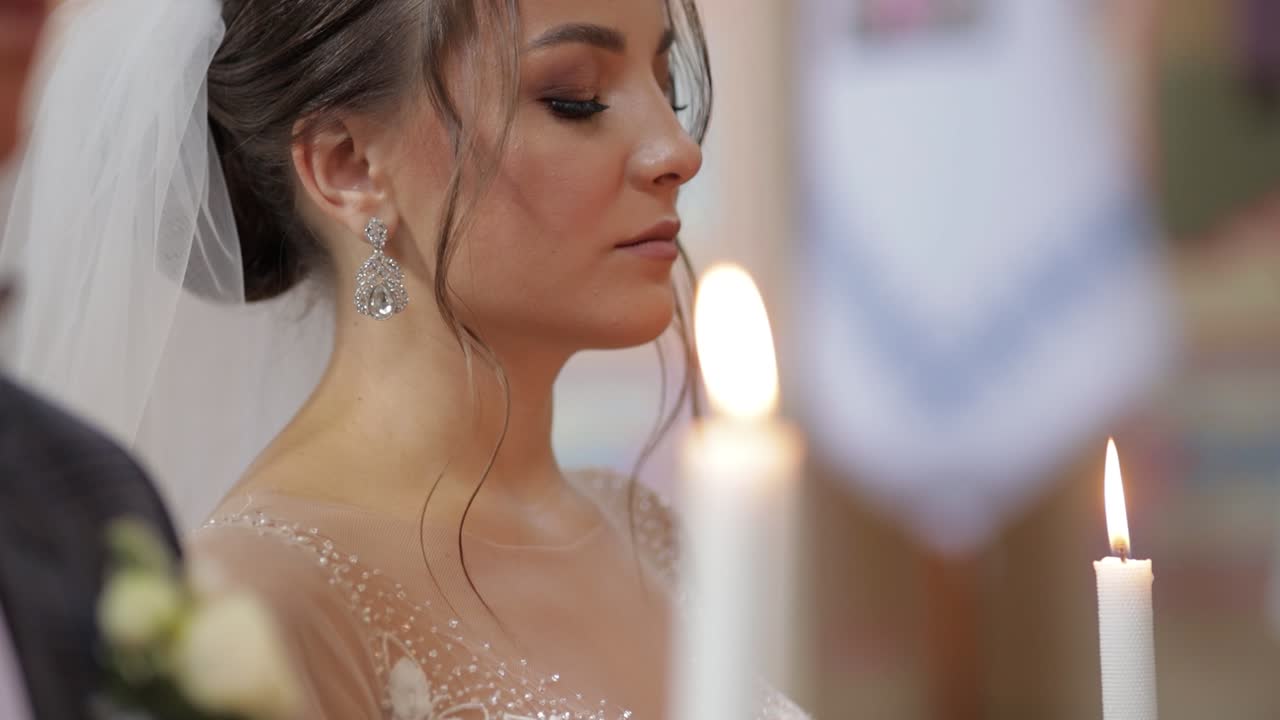 Sposi. La sposa e lo sposo stanno in chiesa, tenendo candele in mano. Cerimonia nuziale