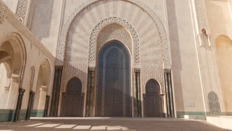 Handheld-tilt-down-establishing-shot-of-Hassan-II-Mosque-in-Morocco,-sunny-day