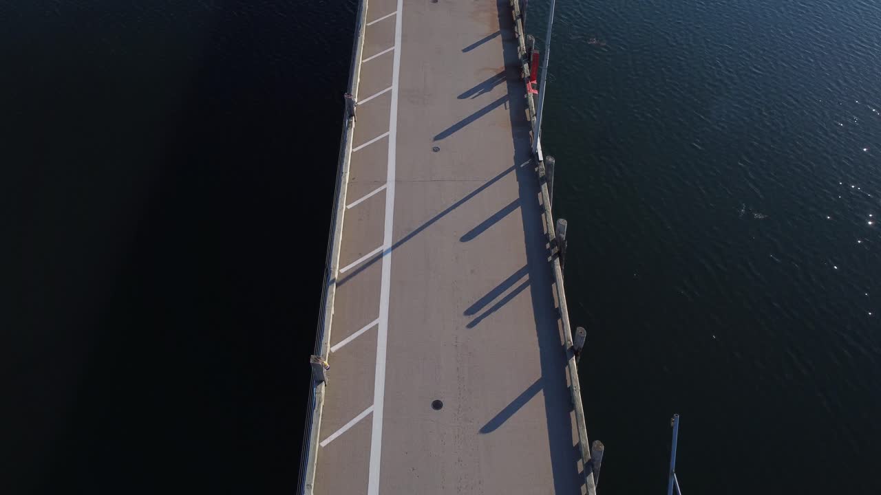 drone aéreo moviéndose lentamente y panorámica sobre el muelle en st-andrews por el mar acercándose a la ciudad por la mañana