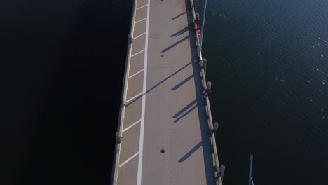 aerial drone moving slowly and panning up over the pier at st-andrews by the sea approaching the town in the morning