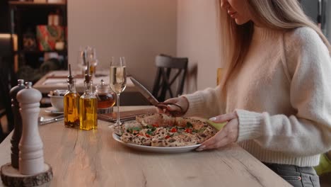 mujer comiendo pizza en un restaurante