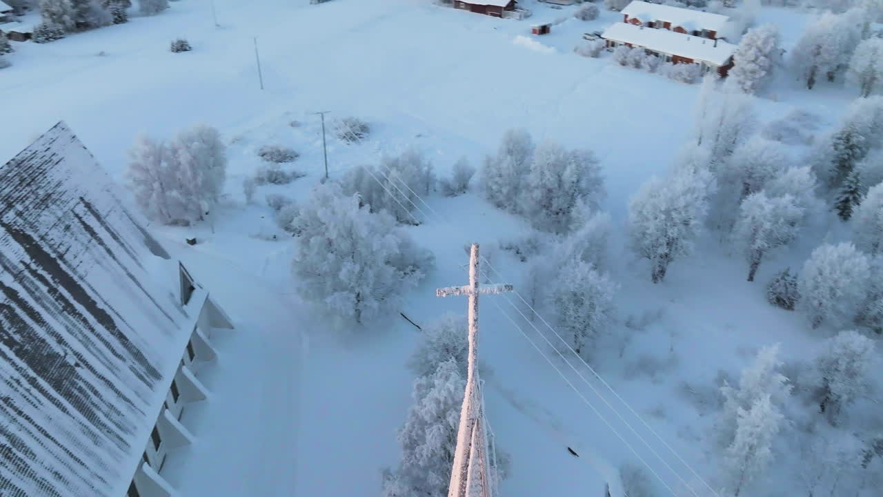 Aerial view circling the cross on the Salla church, winter sunrise in Finland
