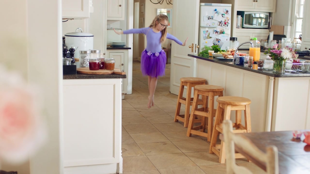 Bambina che Balla in Cucina con un Tutù Viola