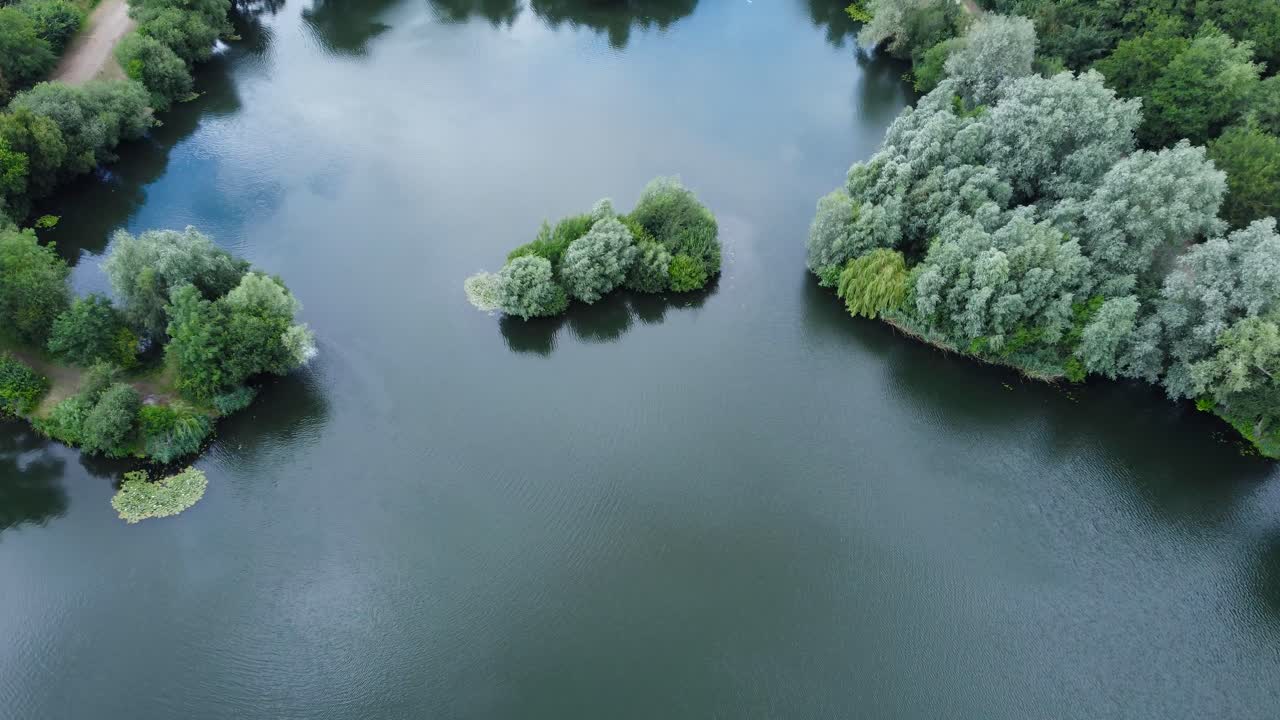 Close up of little island in alderson lake with still water reflection in Needham market