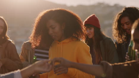 Mujer-Joven-Bailando-Amigos-Multiétnicos-Celebrando-En-La-Azotea-Al-Atardecer-Disfrutando-Del-Fin-De-Semana-De-Fiesta-Divirtiéndose-Socializando-Pasando-El-Rato-Bebiendo