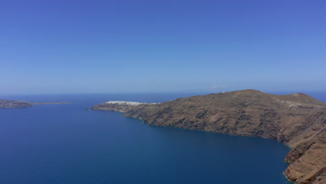 slow panning panoramic drone shot of oia in santorini, greece on a sunny day