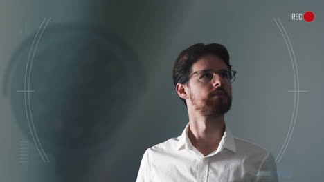 young man worriedly looking around an interrogation room and being monitored by camera