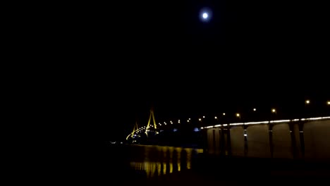 long exposure motion timelapse of beautiful bridge at night with cold frosty window glass in the foreground