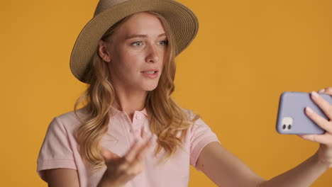 caucasian woman in a hat having video call on smartphone.