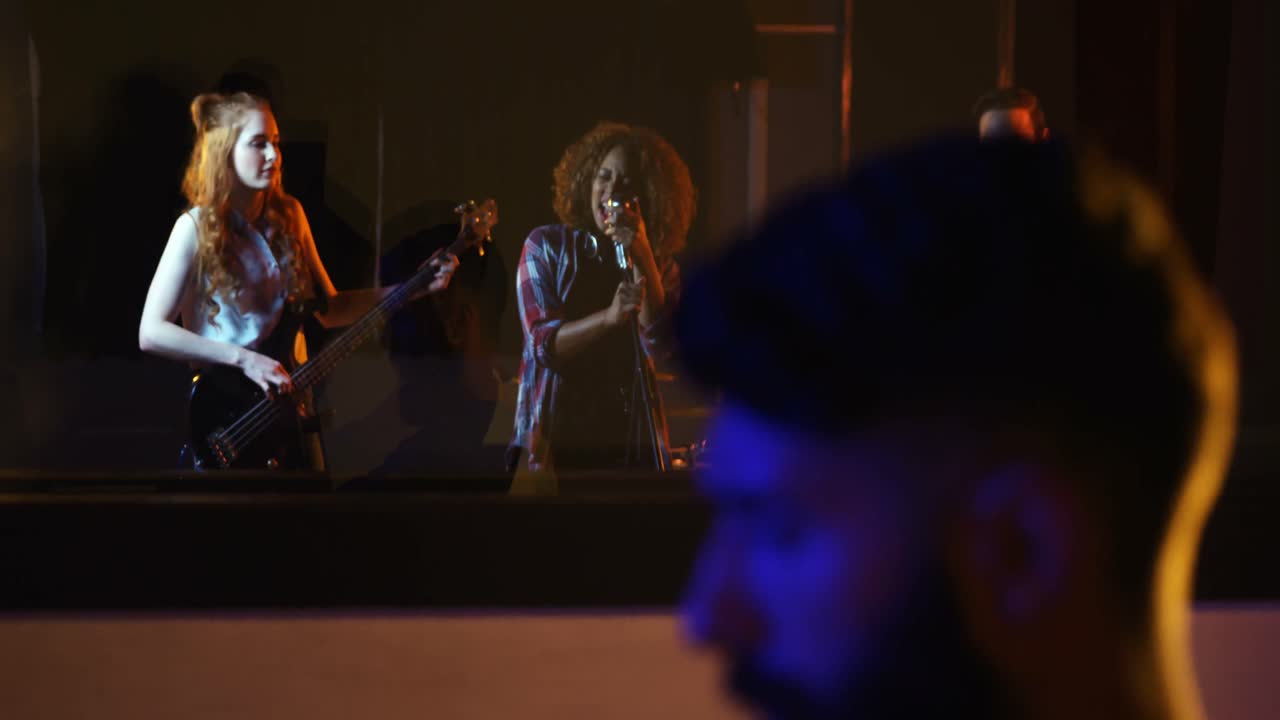 мужской аудиоинженер, показывающий палец вверх к группе во время смешивания звука