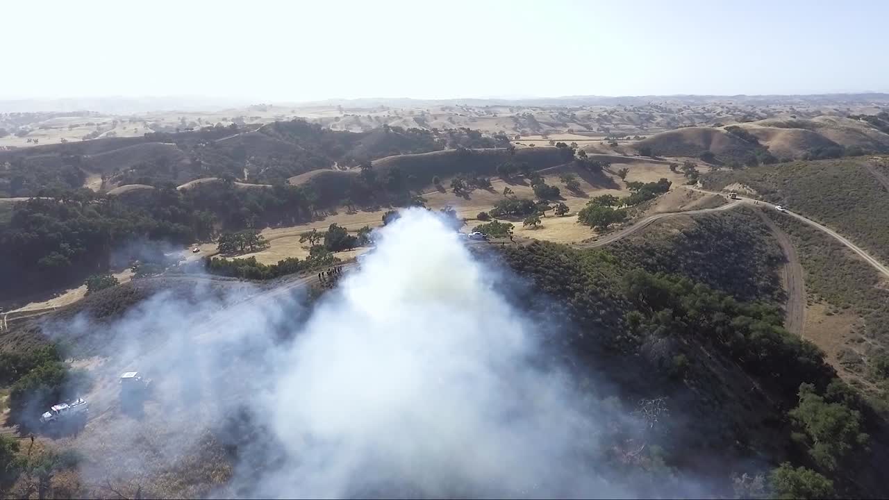 una excavadora acecha en la esquina mientras columnas de humo sobre ella