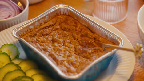 Traditional-pâté-in-a-foil-tray-with-pickles-on-the-side