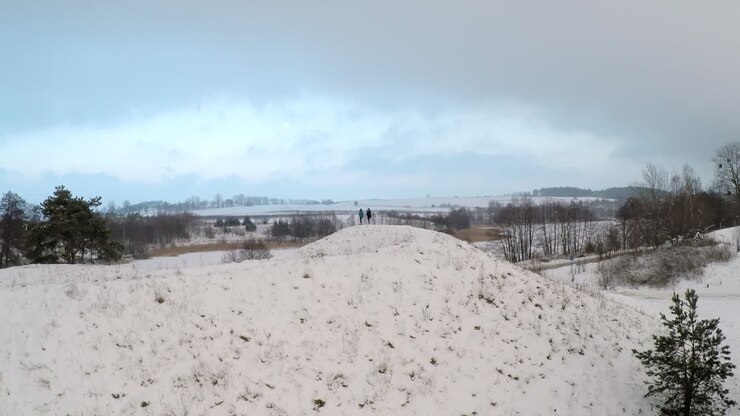 Ragazze che provano yoga su una collina innevata