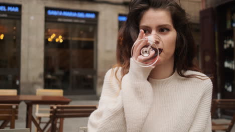 young woman drinking red wine on a terrace