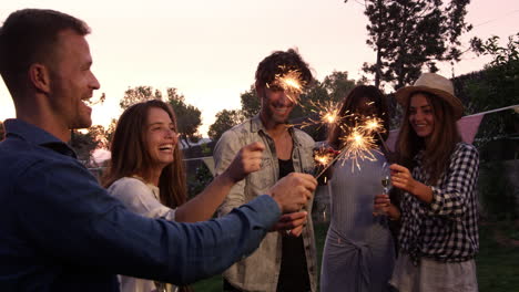 Gruppe-Von-Freunden-Mit-Wunderkerzen,-Die-Eine-Party-Im-Freien-Genießen