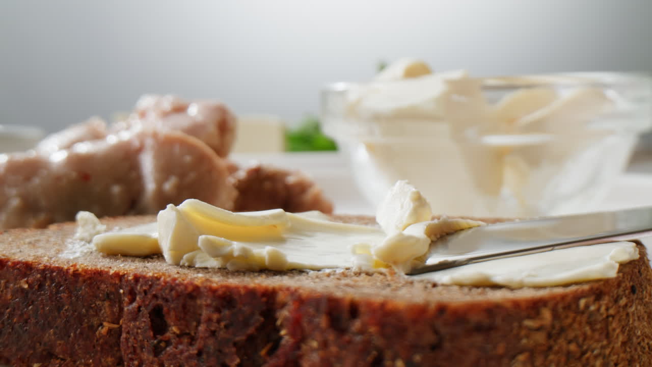 Young woman spreading nut butter onto toast in kitchen, closeup. High quality 4k footage